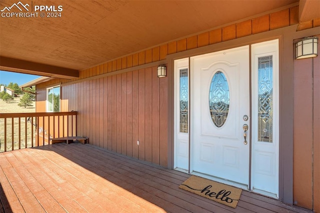 view of exterior entry with a wooden deck