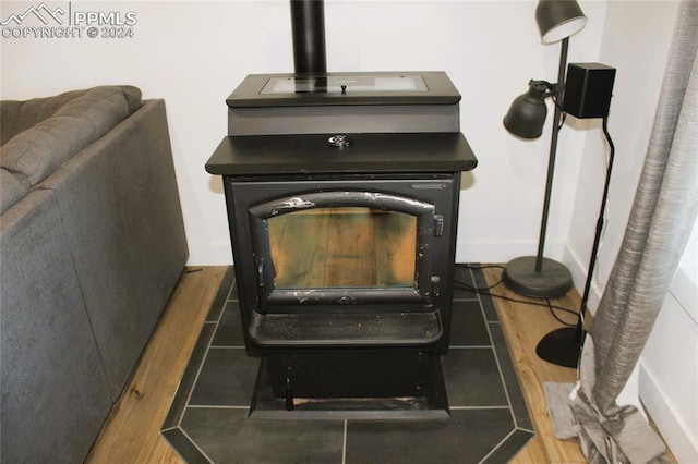 interior details featuring wood-type flooring and a wood stove