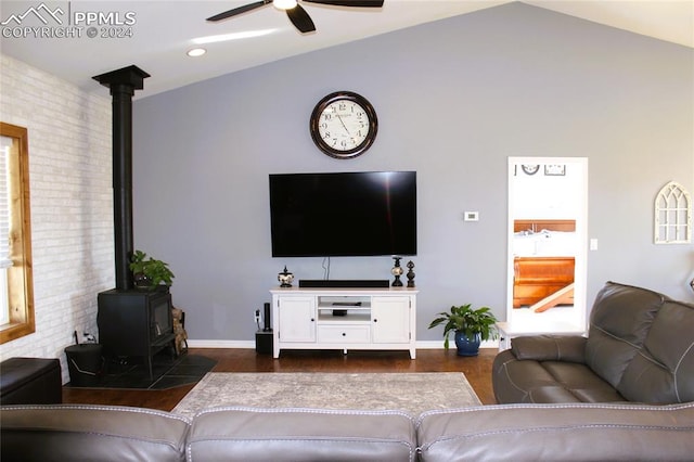 living room featuring lofted ceiling, ceiling fan, and a wood stove