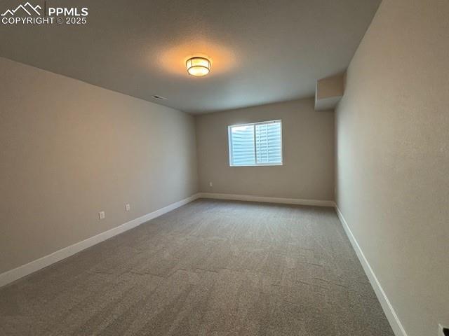 carpeted empty room with baseboards