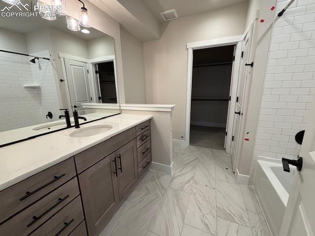 full bath featuring marble finish floor, visible vents, washtub / shower combination, vanity, and baseboards