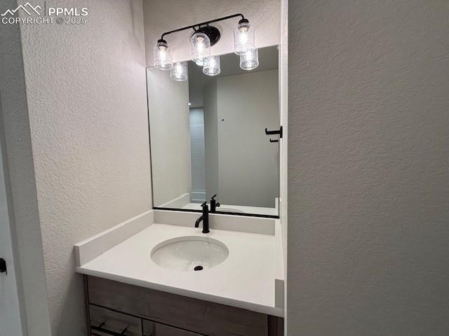 bathroom with vanity and a textured wall