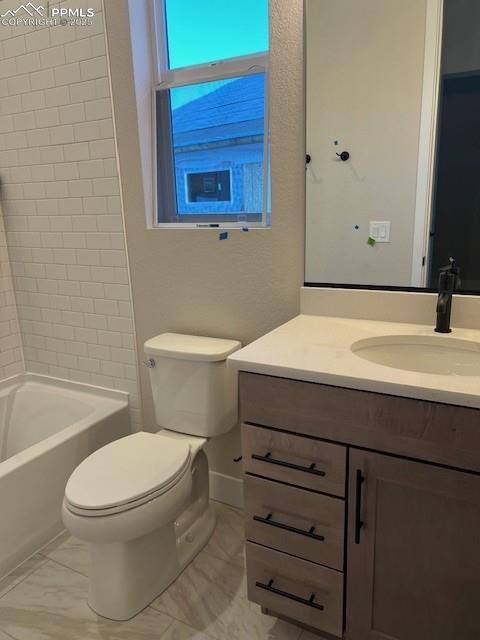 full bathroom with baseboards, toilet, marble finish floor, vanity, and shower / washtub combination