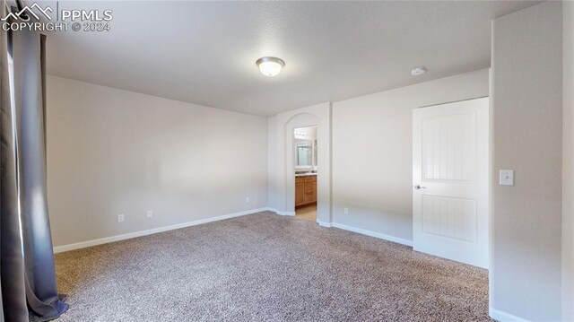 unfurnished bedroom with light colored carpet and ensuite bathroom