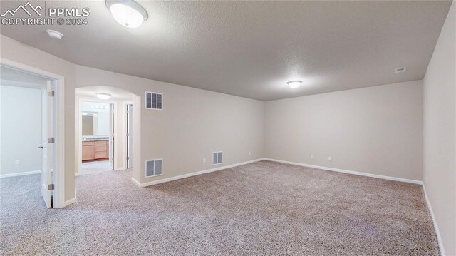 carpeted spare room with a textured ceiling