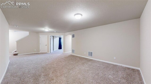 unfurnished room featuring a textured ceiling and carpet floors