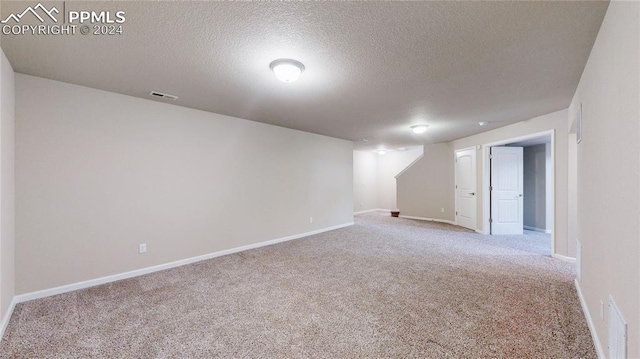 interior space featuring a textured ceiling and light colored carpet