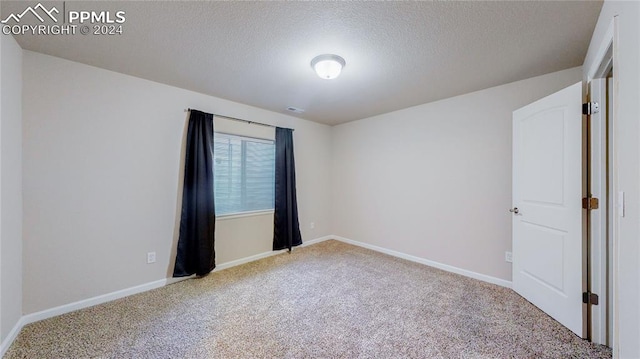 carpeted spare room featuring a textured ceiling