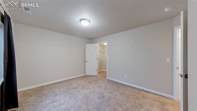 carpeted spare room with a textured ceiling