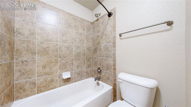 bathroom with tiled shower / bath and toilet