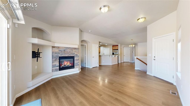 unfurnished living room featuring hardwood / wood-style flooring, a fireplace, and vaulted ceiling