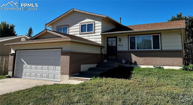 tri-level home featuring a garage and a front lawn