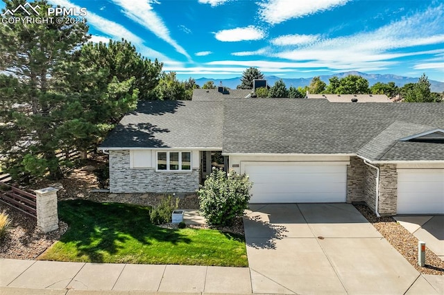 ranch-style home featuring a garage and a mountain view