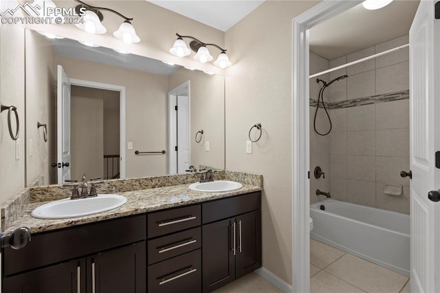 bathroom with tile patterned flooring, vanity, and tiled shower / bath