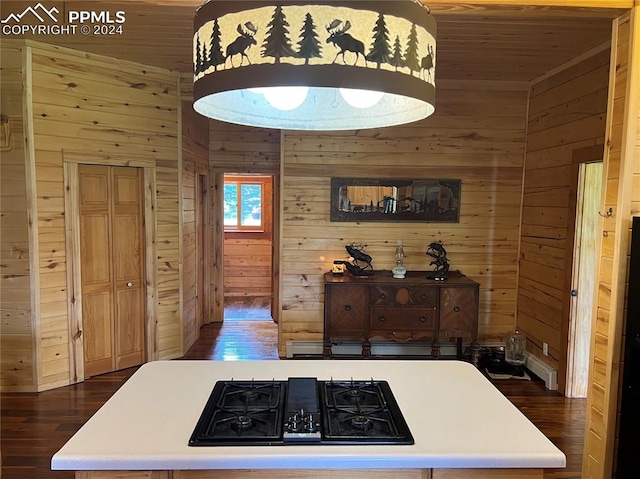 kitchen with black gas stovetop, wooden walls, and dark hardwood / wood-style flooring