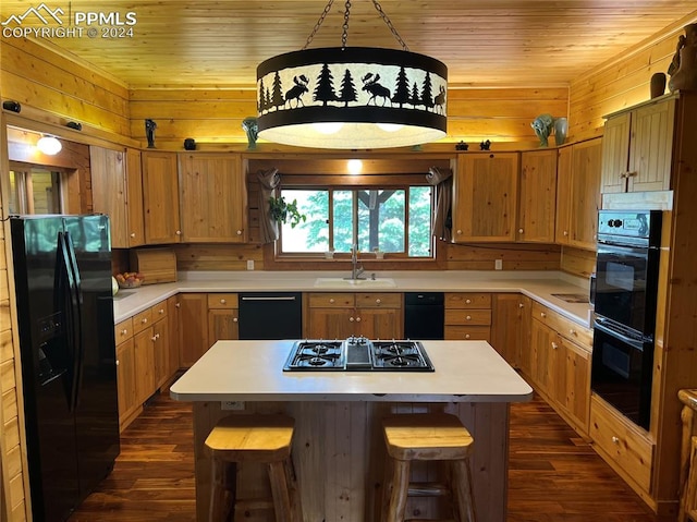 kitchen featuring black appliances, a center island, dark wood-type flooring, and sink