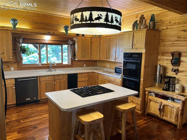 kitchen with pendant lighting, a center island, sink, black appliances, and dark hardwood / wood-style flooring