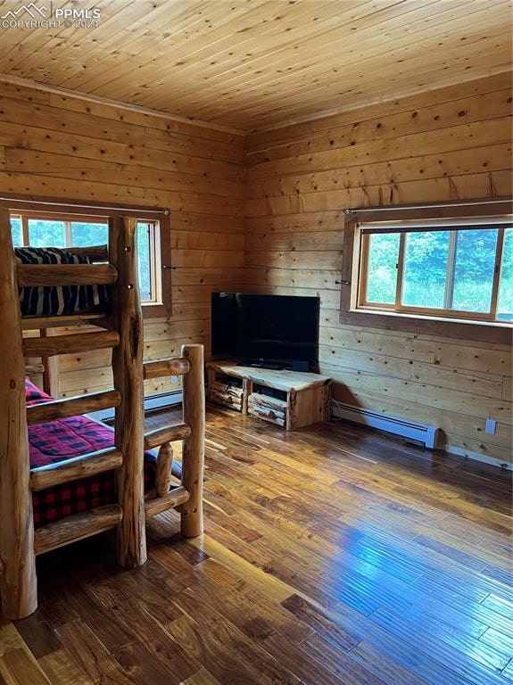 bedroom with a baseboard radiator, wooden walls, hardwood / wood-style floors, and wooden ceiling