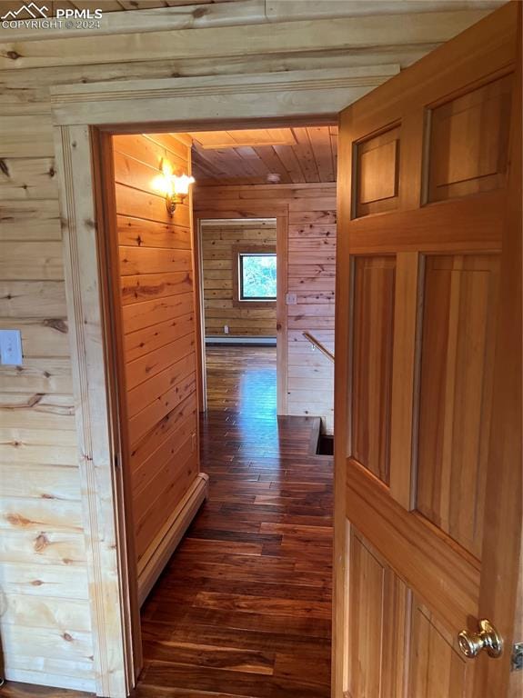 corridor featuring wooden walls and dark wood-type flooring