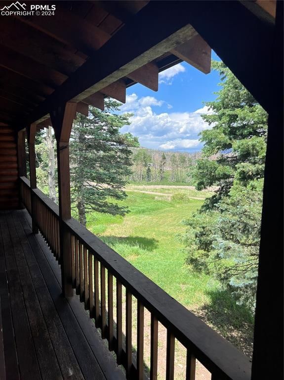 wooden deck featuring a lawn