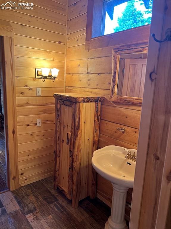 bathroom with wood walls and hardwood / wood-style flooring