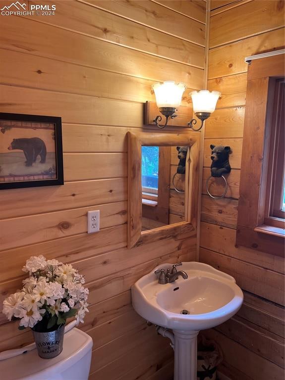 bathroom with wooden walls and toilet