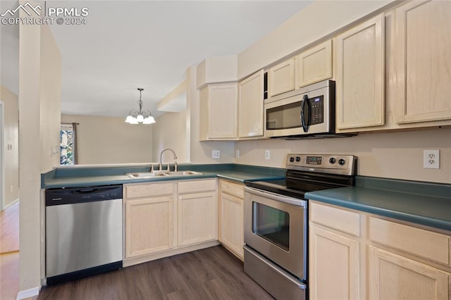 kitchen featuring hanging light fixtures, sink, appliances with stainless steel finishes, a notable chandelier, and dark hardwood / wood-style flooring