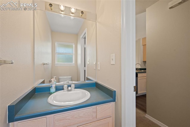 bathroom with tile patterned flooring, vanity, and toilet