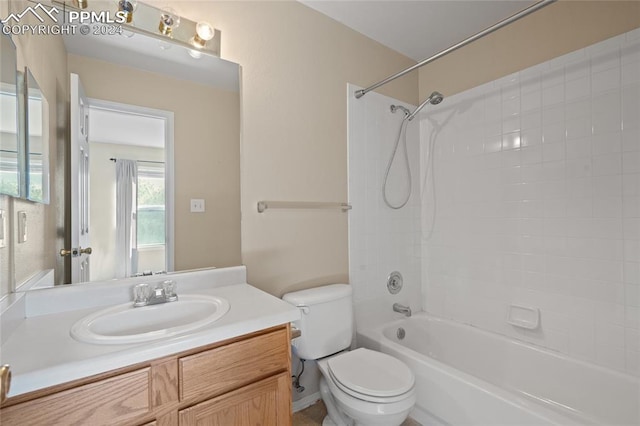 full bathroom featuring vanity, tiled shower / bath combo, and toilet