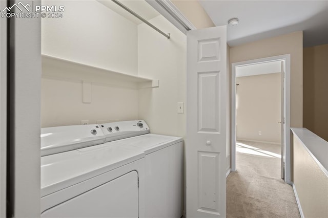 laundry room featuring washer and dryer and light colored carpet