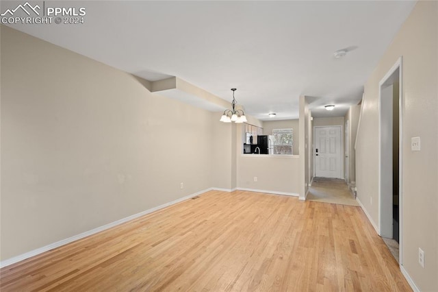 unfurnished room featuring light hardwood / wood-style flooring and a notable chandelier