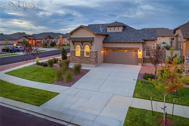 view of front of property featuring a garage and a front lawn