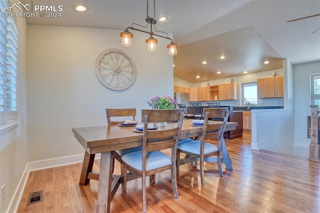 dining area with light hardwood / wood-style floors and vaulted ceiling