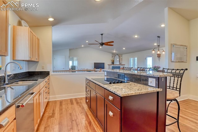 kitchen featuring a breakfast bar, black electric stovetop, dishwasher, ceiling fan with notable chandelier, and vaulted ceiling