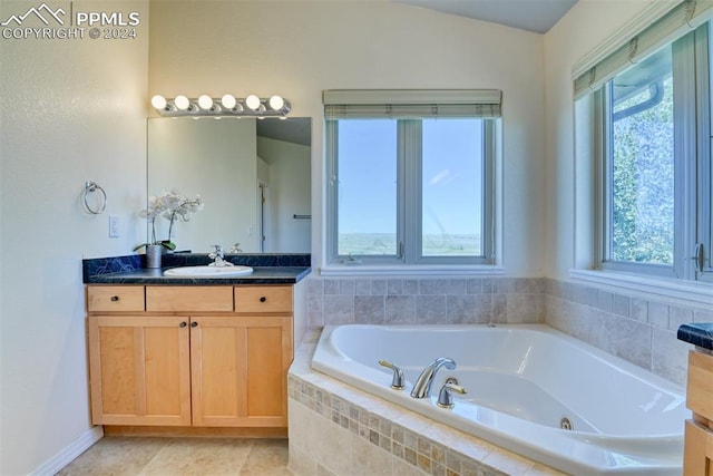 bathroom featuring tiled tub and vanity