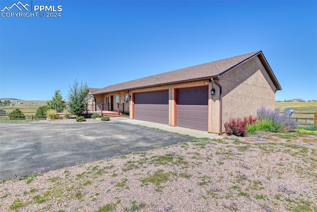 exterior space featuring a rural view and a garage