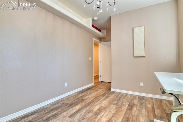 interior space with wood-type flooring and an inviting chandelier