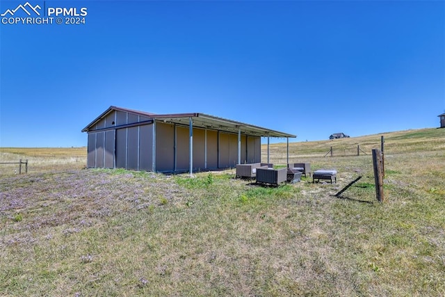 view of yard with a rural view and an outdoor structure