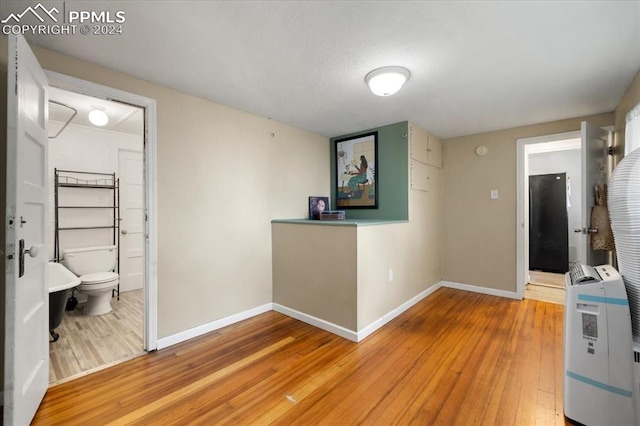 hallway featuring wood-type flooring and heating unit