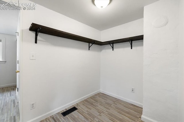 spacious closet with light hardwood / wood-style floors