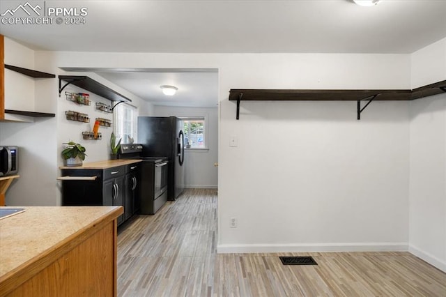 kitchen with appliances with stainless steel finishes and light hardwood / wood-style floors