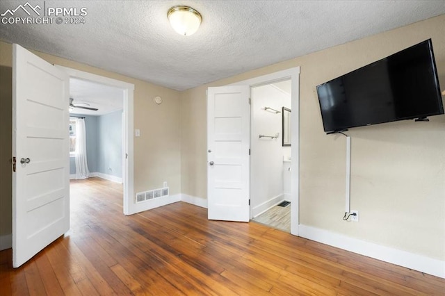 spare room with wood-type flooring, a textured ceiling, and ceiling fan