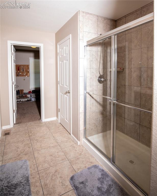 6777 Ironwood Tree Cir, Colorado Springs, CO 80927 - full bath with tile patterned flooring, baseboards, and a shower stall