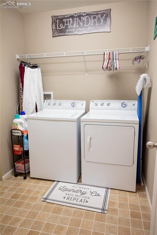 6777 Ironwood Tree Cir, Colorado Springs, CO 80927 - washroom with baseboards, laundry area, and washing machine and clothes dryer