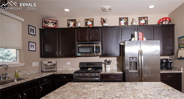 6777 Ironwood Tree Cir, Colorado Springs, CO 80927 - kitchen with light stone counters, a sink, a toaster, and stainless steel appliances
