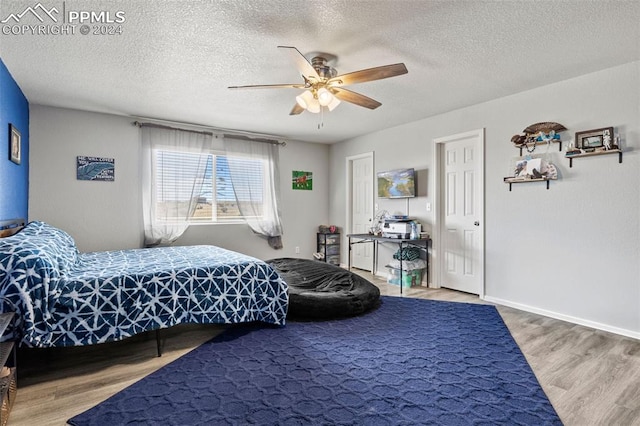 bedroom featuring ceiling fan, hardwood / wood-style flooring, and a textured ceiling