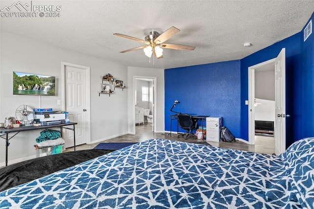 bedroom with a textured ceiling, connected bathroom, ceiling fan, and hardwood / wood-style flooring