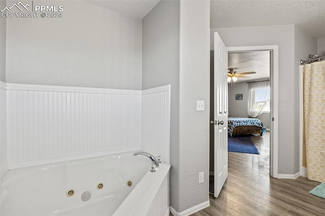 bathroom with a textured ceiling, wood-type flooring, separate shower and tub, and ceiling fan