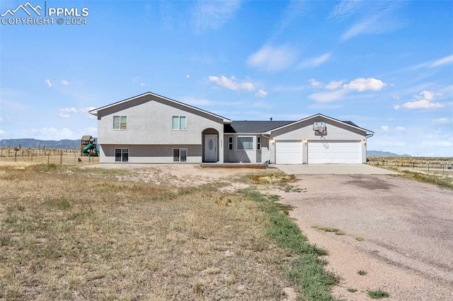 view of front of house with a rural view and a garage