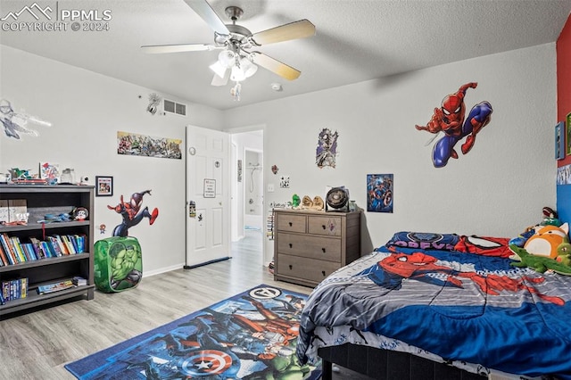 bedroom featuring ceiling fan, a textured ceiling, and light hardwood / wood-style flooring